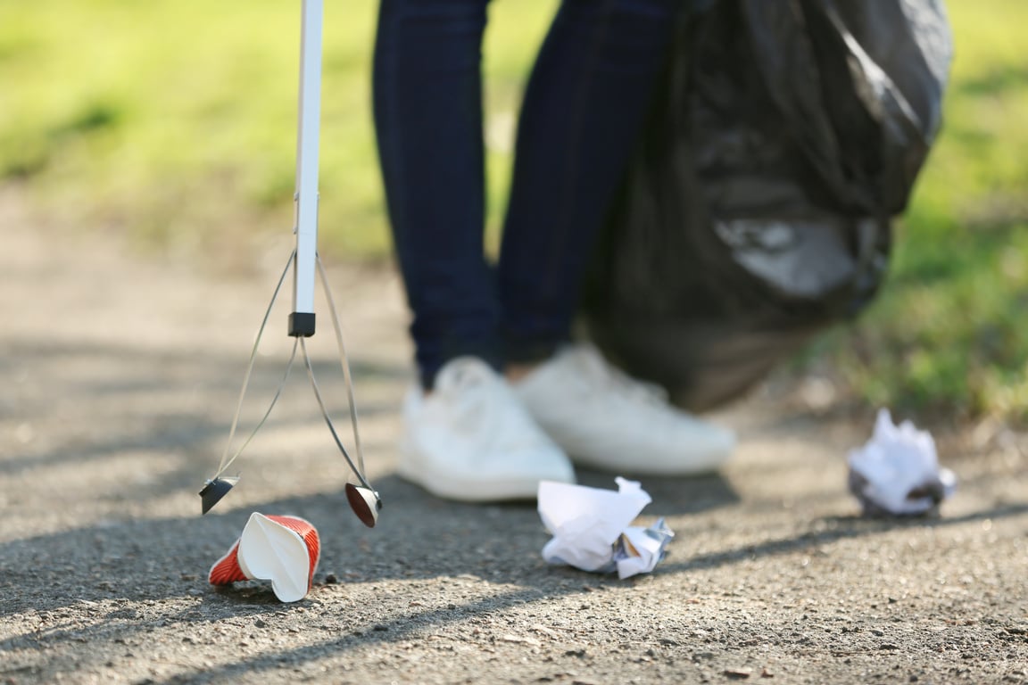 Young Volunteer Picking up Litter in Park