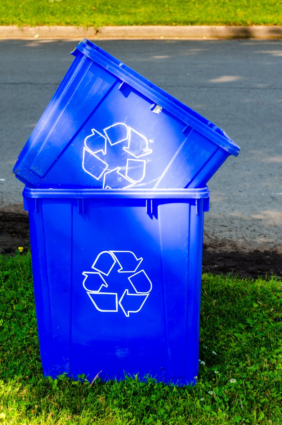 Two empty roadside recycling bins stacked at curbside